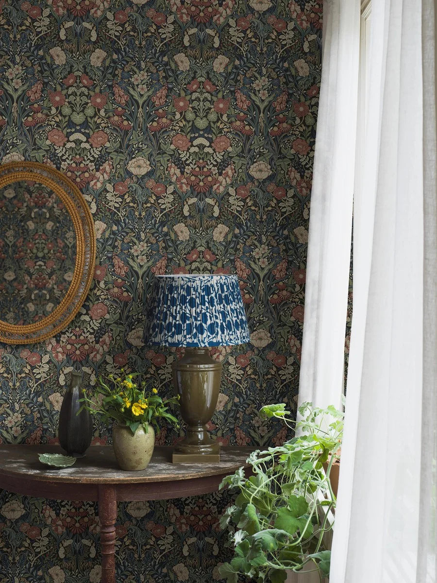 Immerse yourself in the traditional and classic charm of our Örtagård wallpaper in muted dark tones of burgundy, blue, olive green, yellow and cream on a bold black background.
