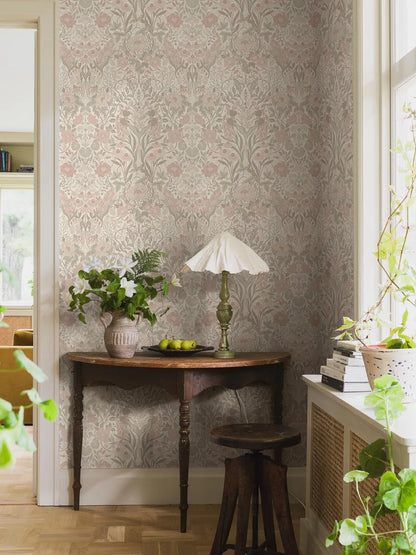 Embrace the dreamy and romantic allure of our Örtagård wallpaper in a powdery pastel palette of pink, green, muted red and light beige. 