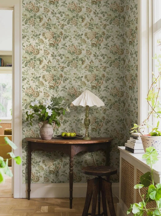 Indulge in the romantic warmth of our Hortensia wallpaper in apricot pink, brown, green, and cream tones, on an eggshell white base.