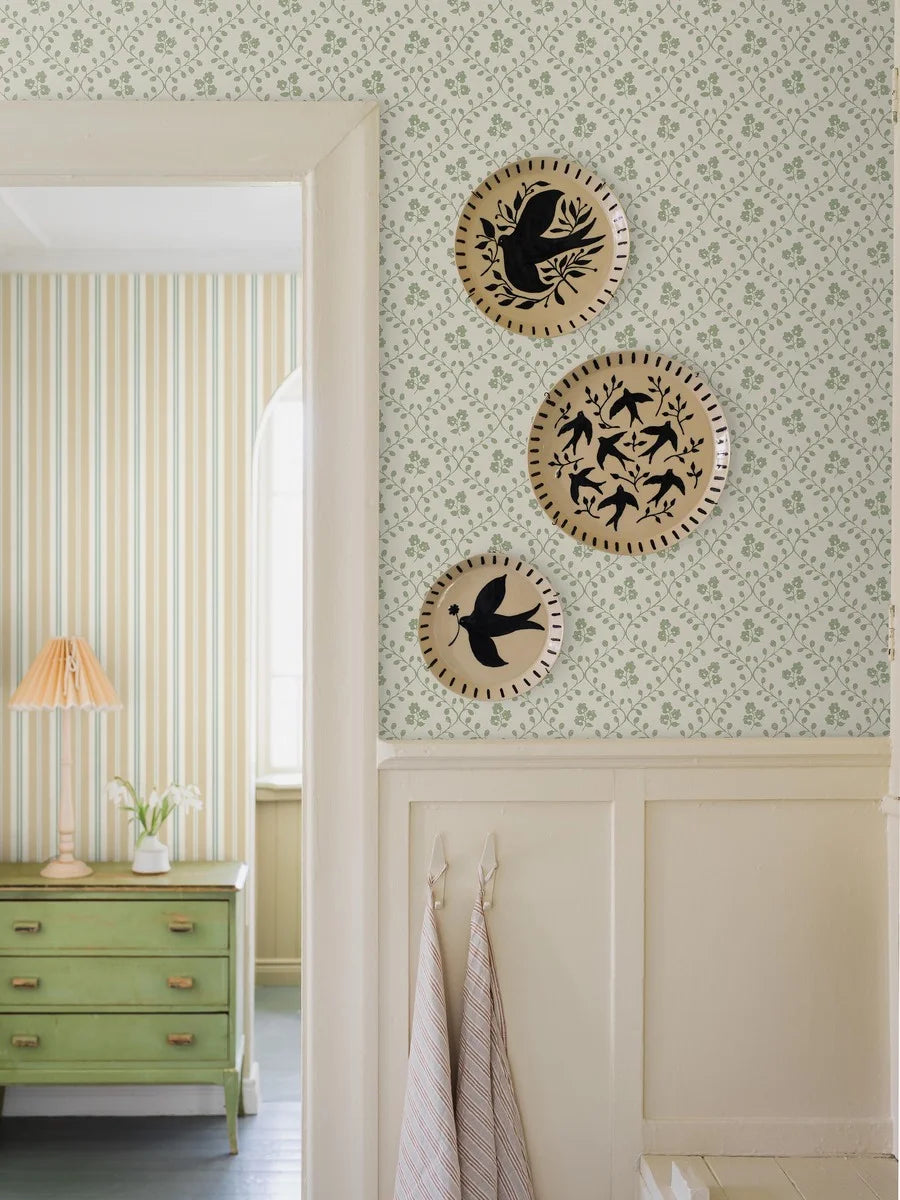Set on a warm white base with a beautiful green floral trellis pattern, our Idun wallpaper evokes the freshness of a spring garden.