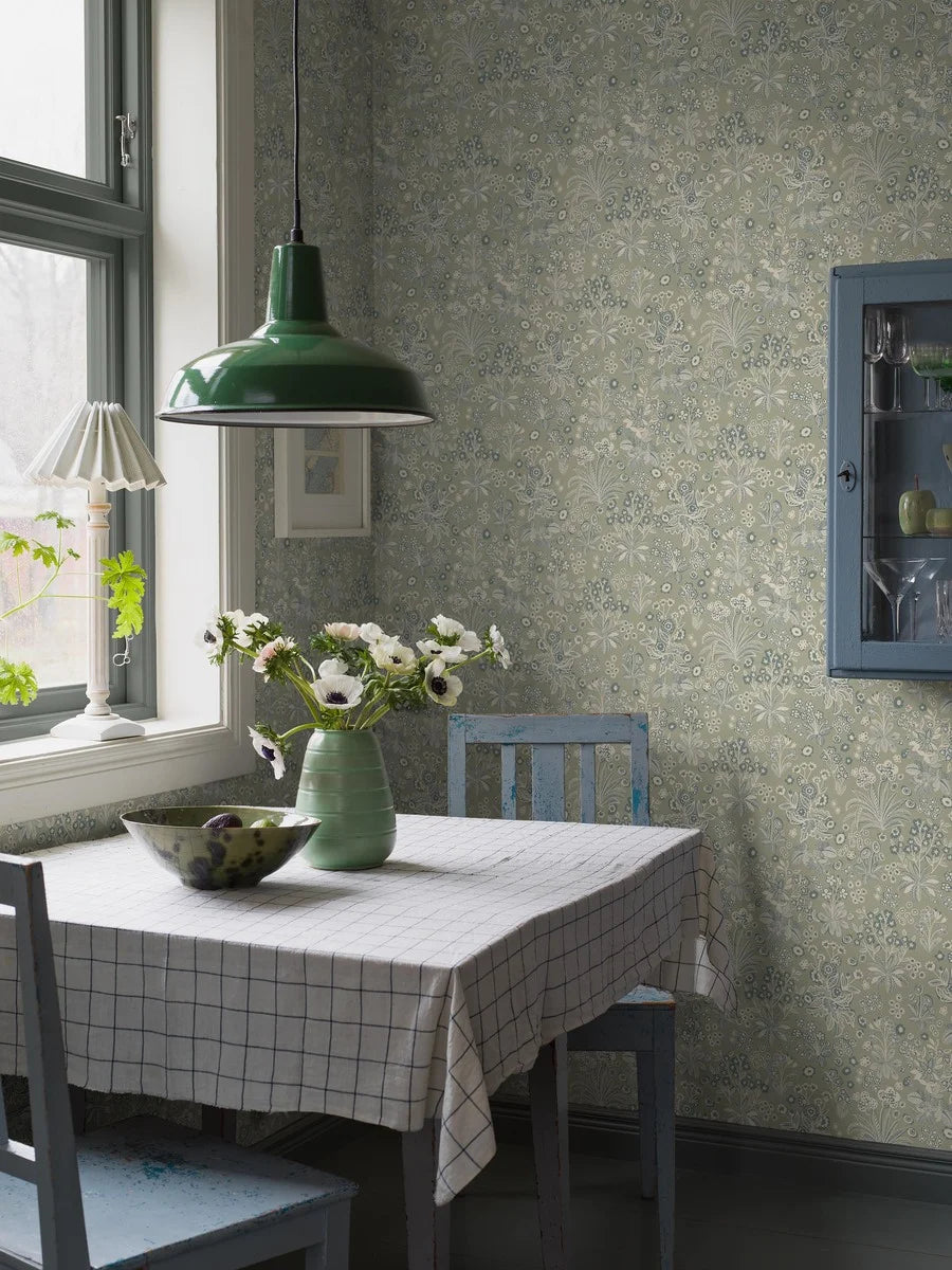 Colored in a soft light green background with delicate white and petrol blue details our Tuva wallpaper is whimsical and fun.