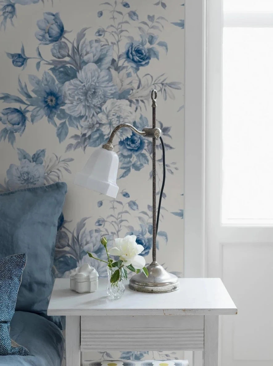 Cast on a pristine white base, this wallpaper features delicate porcelain blue flowers reminiscent of the hand-painted Chinese porcelain that has been a classic symbol of elegance and sophistication since the 17th century