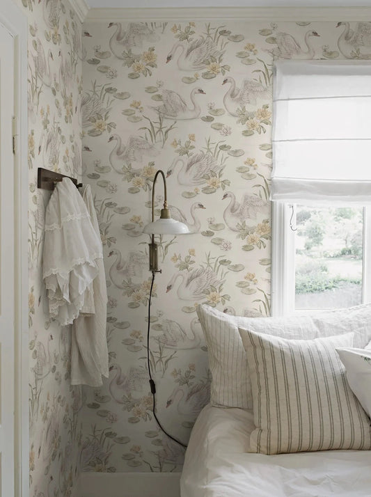 Our Lily Swan children’s wallpaper in light yellow and green tones on a warm white background exudes a gentle and playful vibe. 