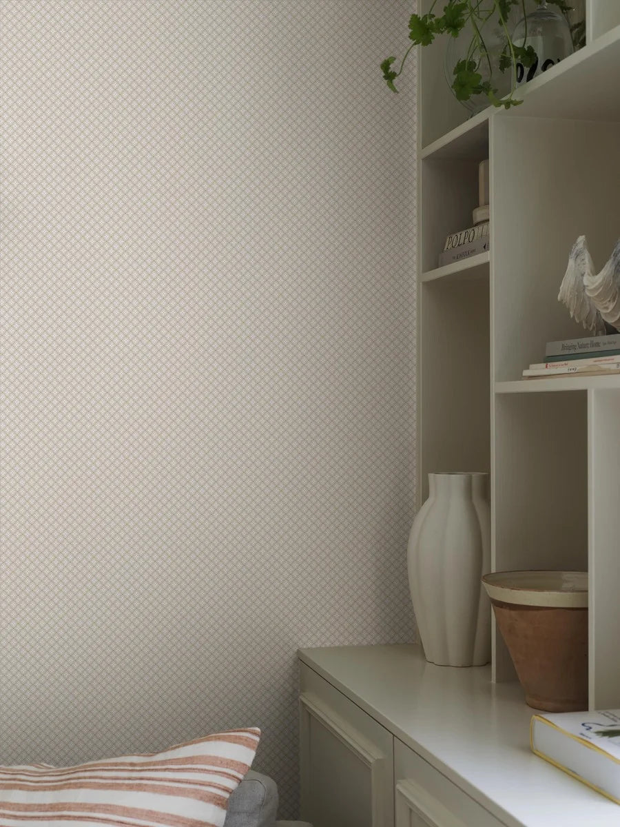  This Selma wallpaper has a petite, geometric pattern consisting of cream-colored flowers with gold detailing on a pearl grey background. 