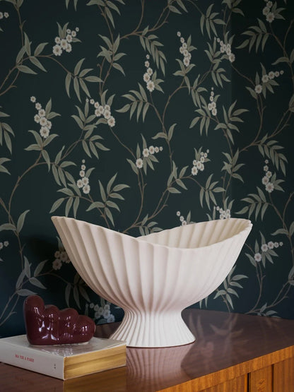 Our Floral Tree wallpaper pairs green leaves and white flowers with a charcoal black background, to create a bold, sophisticated design.