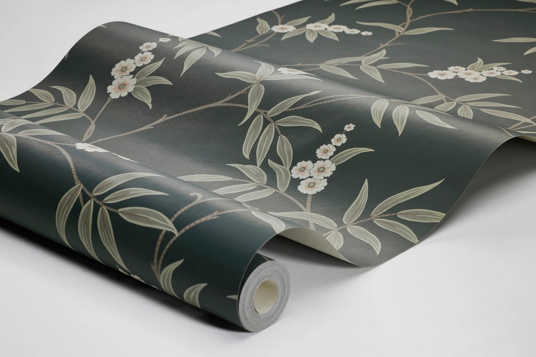 Our Floral Tree wallpaper pairs green leaves and white flowers with a charcoal black background, to create a bold, sophisticated design.