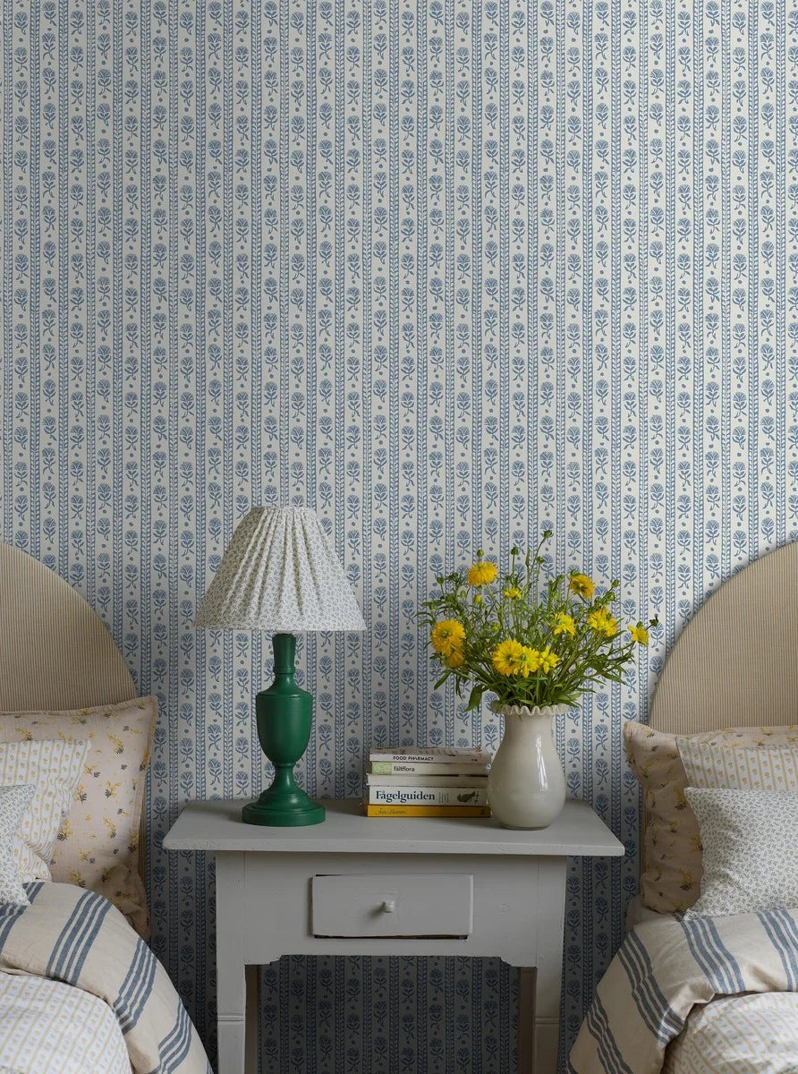  Porcelain blue carnations stretch gently across a clean white background in this Nejlikerand wallpaper. 