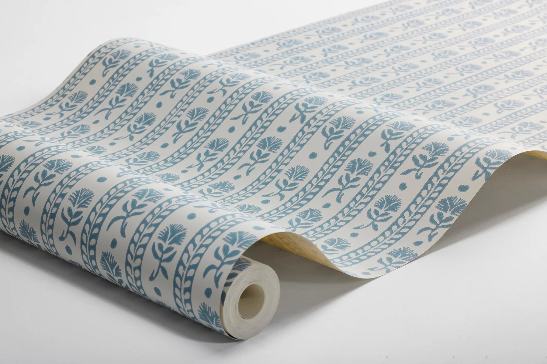 Roll of wallpaper with blue floral pattern on a white background