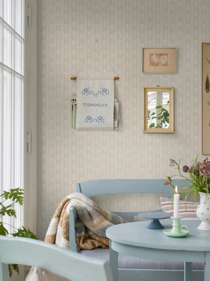 Dining room with light blue chairs, a small table, and decorative elements on a neutral wall.