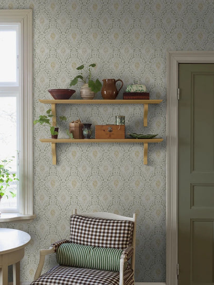 Colored in a bright yet cosy color scheme, our Kvarnholmen wallpaper features a stencil design, printed in soft green and ochre over a warm white background, with accents of sand-toned beige.