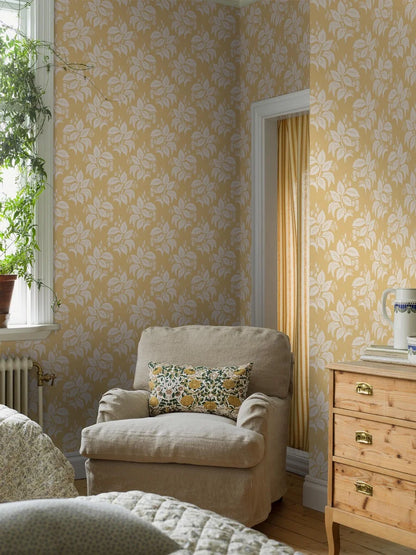 Our Tengbergska wallpaper offers a warm and cheerful take on an early 19th-century French wallpaper design, featuring a grey and white print on a yellow background.