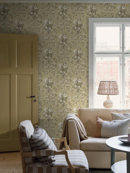 Colored in a muted yellow with beige and grey-brown detailing, our Tullgarn wallpaper brings graceful and royal elegance to your space.