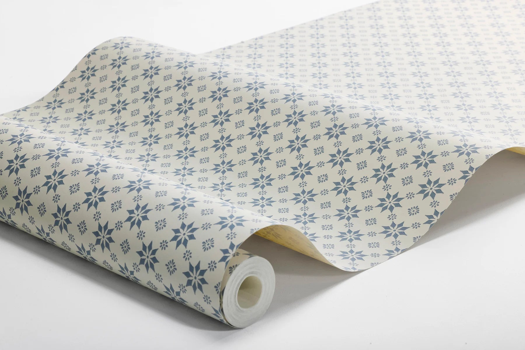  Set on a natural background with muted blue detailing, our Stella wallpaper balances structure and whimsy perfectly. 