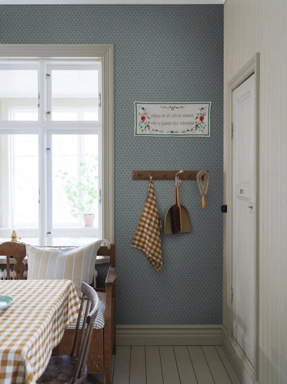  Muted blue tones pair with dark green accents in our Svea wallpaper for a nostalgic palette that is full of depth. 
