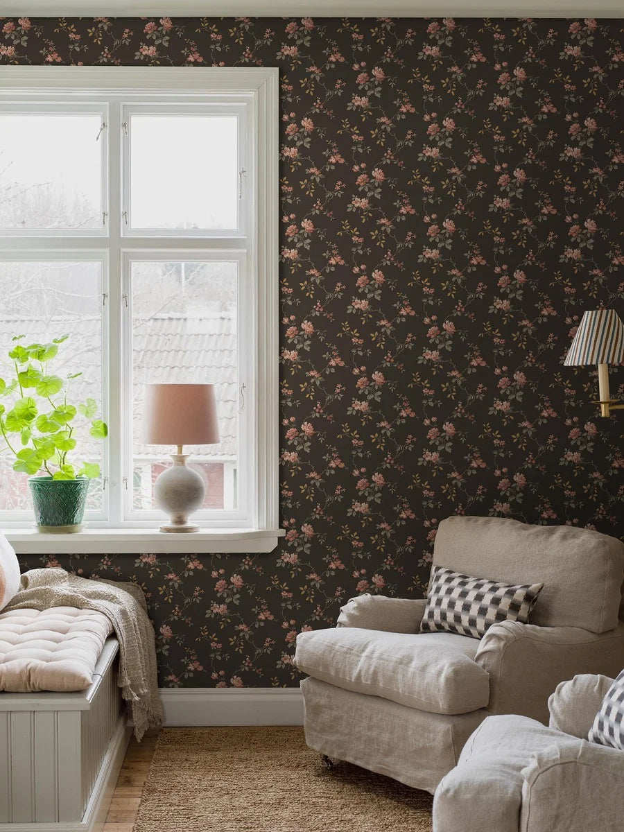  Delicate red and pink roses and grey-brown and copper-toned leaves unfurl across a deep, dramatic brown base in this Värmdö wallpaper. 