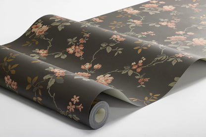  Delicate red and pink roses and grey-brown and copper-toned leaves unfurl across a deep, dramatic brown base in this Värmdö wallpaper. 