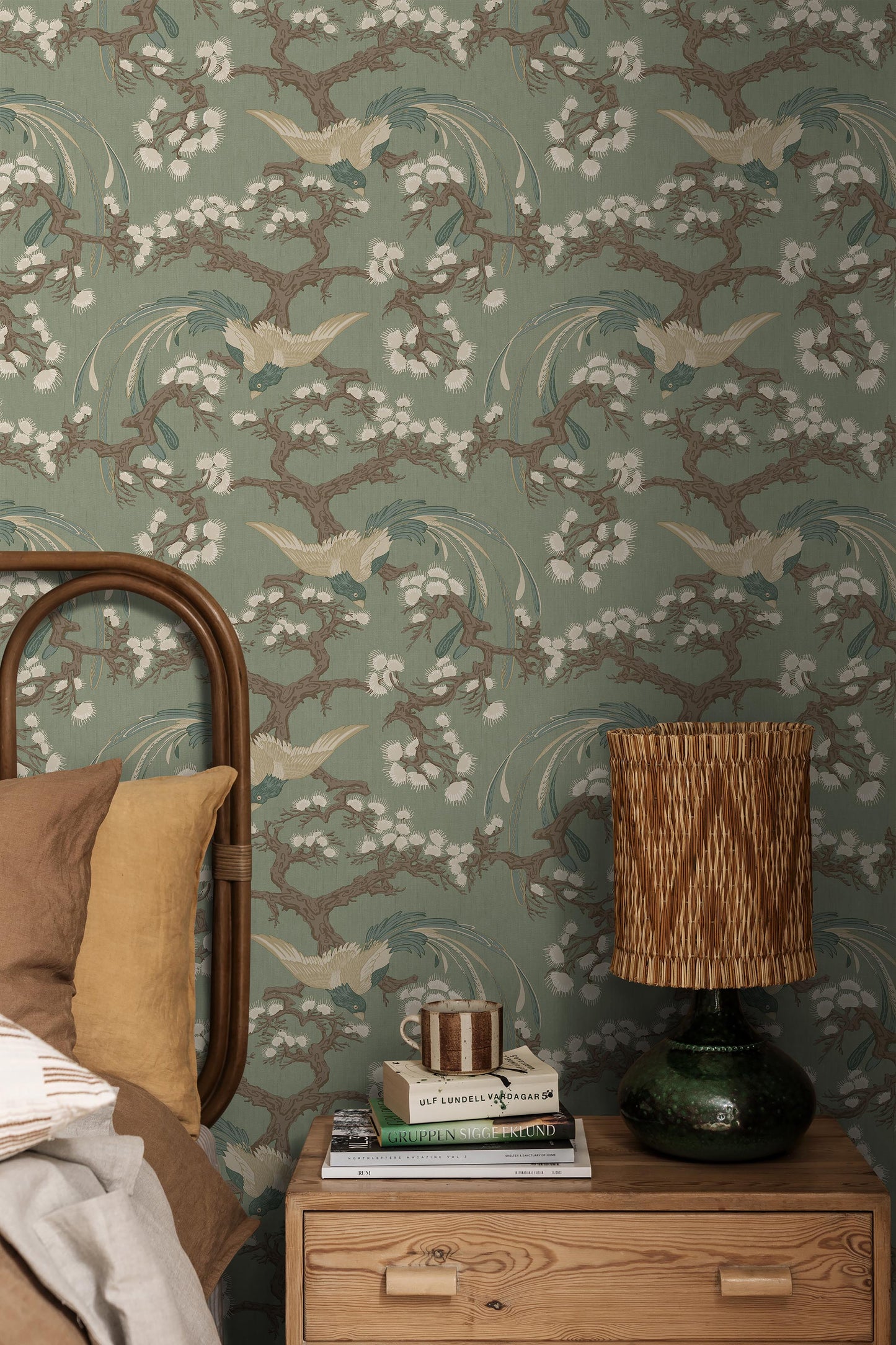 Fenix wallpaper features a deep green backdrop enriched with detailing in blue, brown and cream, creating an elegant and decorative presence on the wall.
