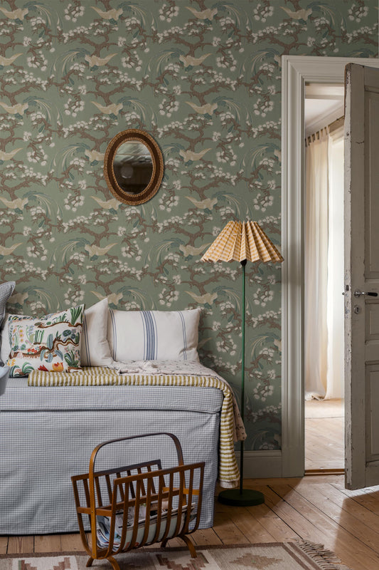 Fenix wallpaper features a deep green backdrop enriched with detailing in blue, brown and cream, creating an elegant and decorative presence on the wall.