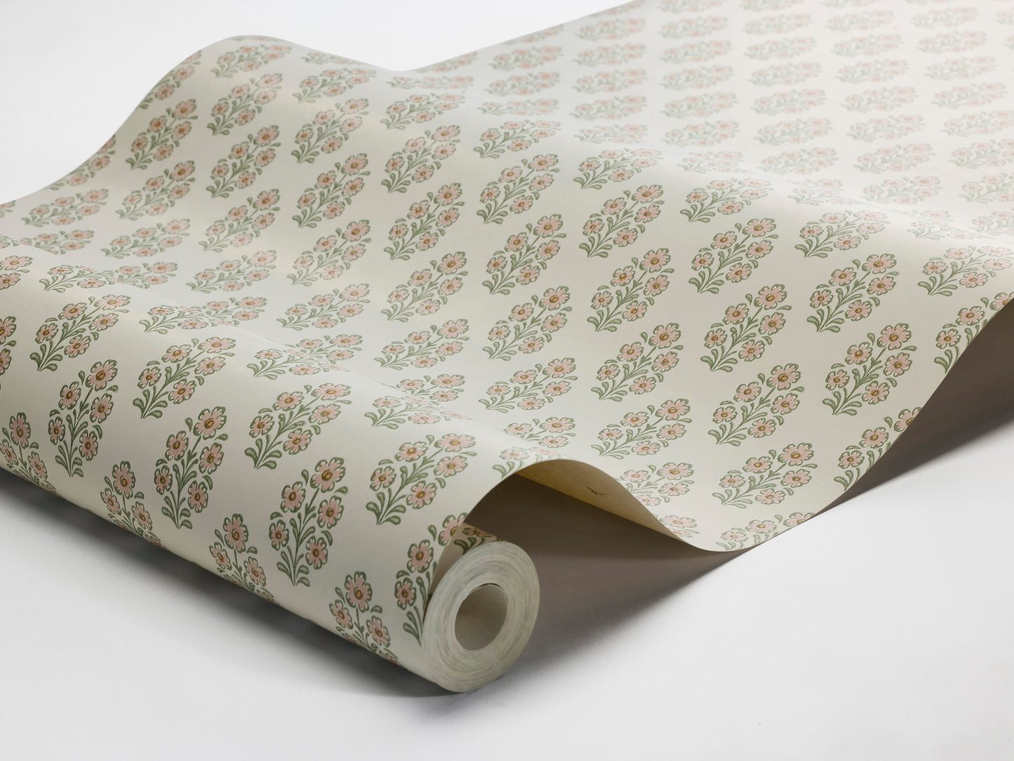 Set against a cream-white background, this Sibylla wallpaper is adorned with pale pink flowers with apricot centres and leaves in soft green tones, arranged in gentle, rhythmic bouquets.