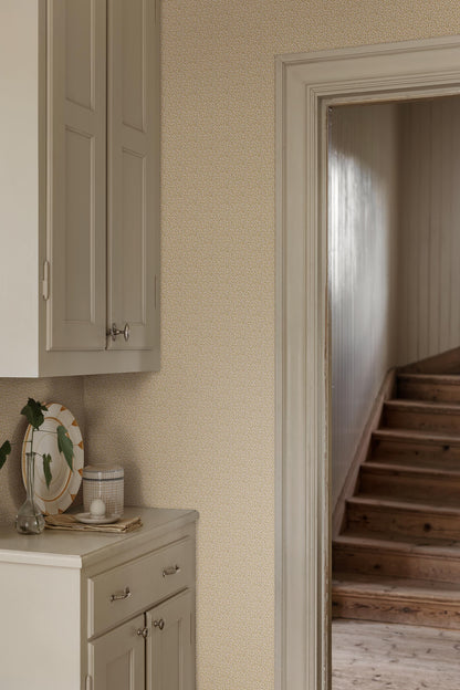 Colored in soft yellow tones, our Ida wallpaper features delicate, intertwining vines scattered with tiny leaves and subtle florals.