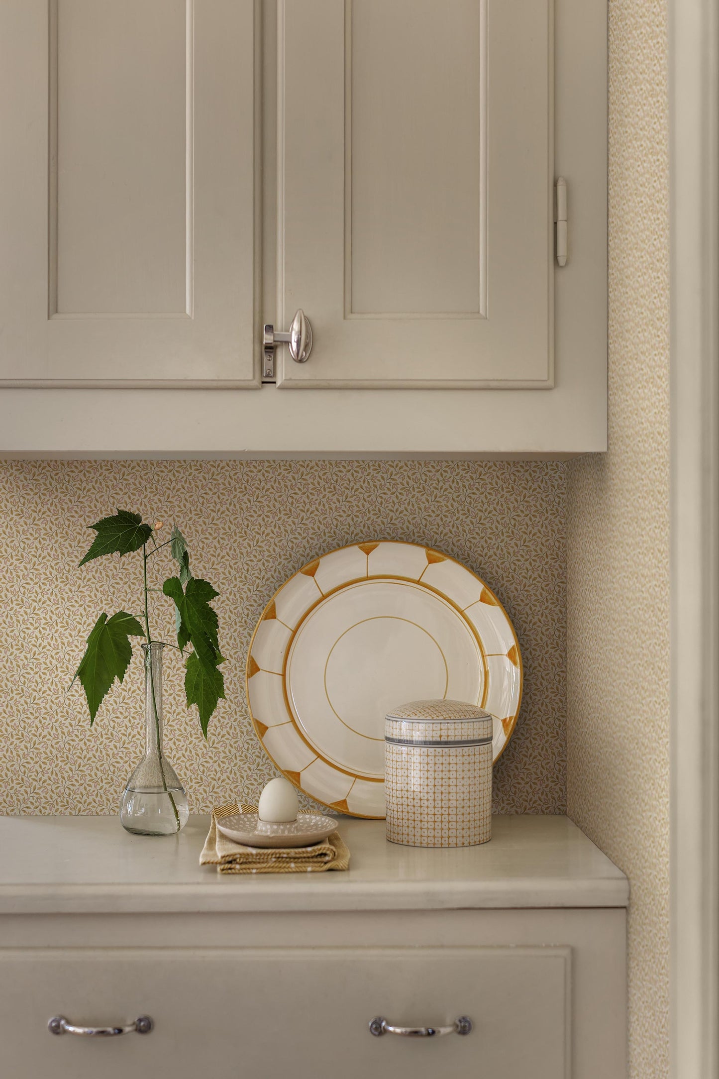 Colored in soft yellow tones, our Ida wallpaper features delicate, intertwining vines scattered with tiny leaves and subtle florals.