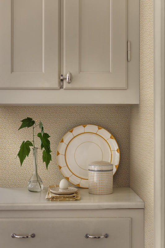 Colored in soft yellow tones, our Ida wallpaper features delicate, intertwining vines scattered with tiny leaves and subtle florals.