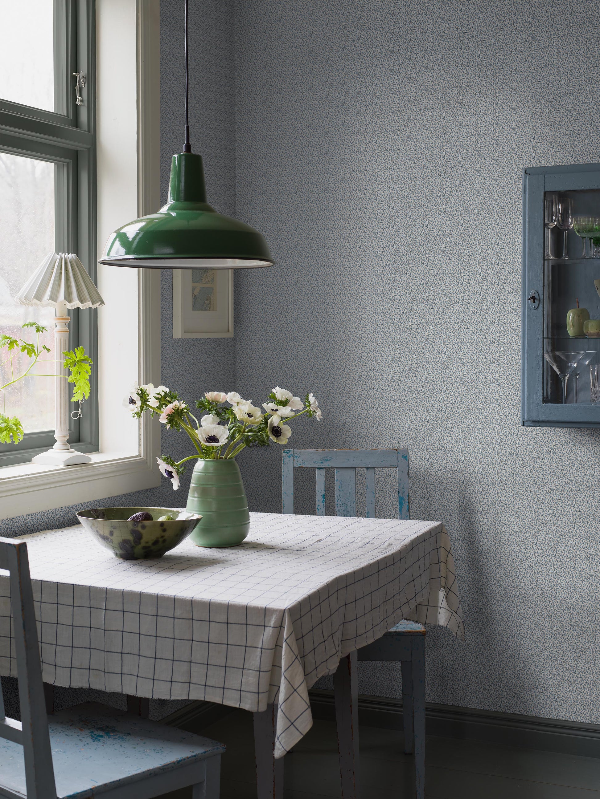 Colored in airy light blue tones, our Ida wallpaper features fine leafy vines that weave naturally across the wall. 