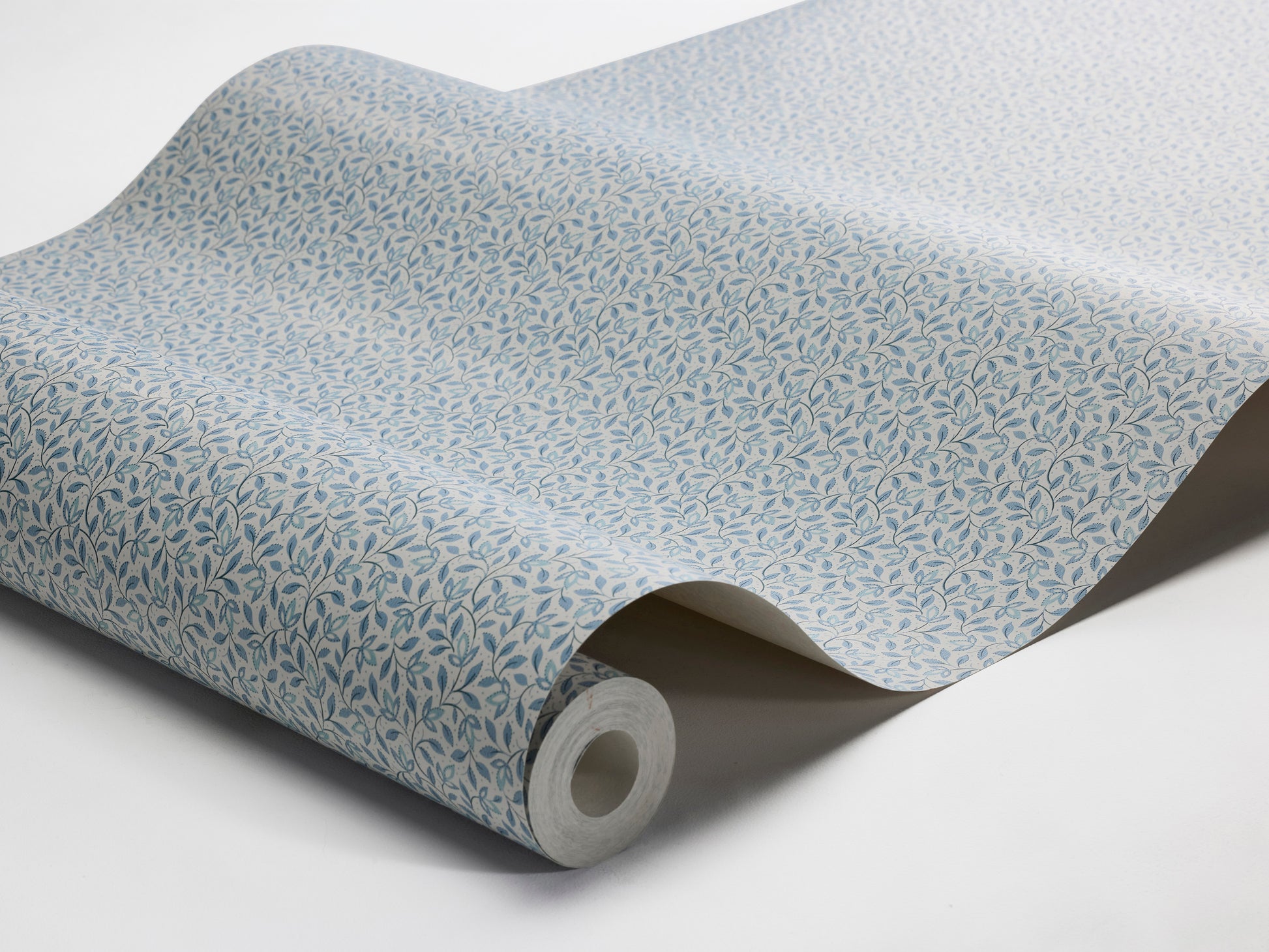 Colored in airy light blue tones, our Ida wallpaper features fine leafy vines that weave naturally across the wall. 