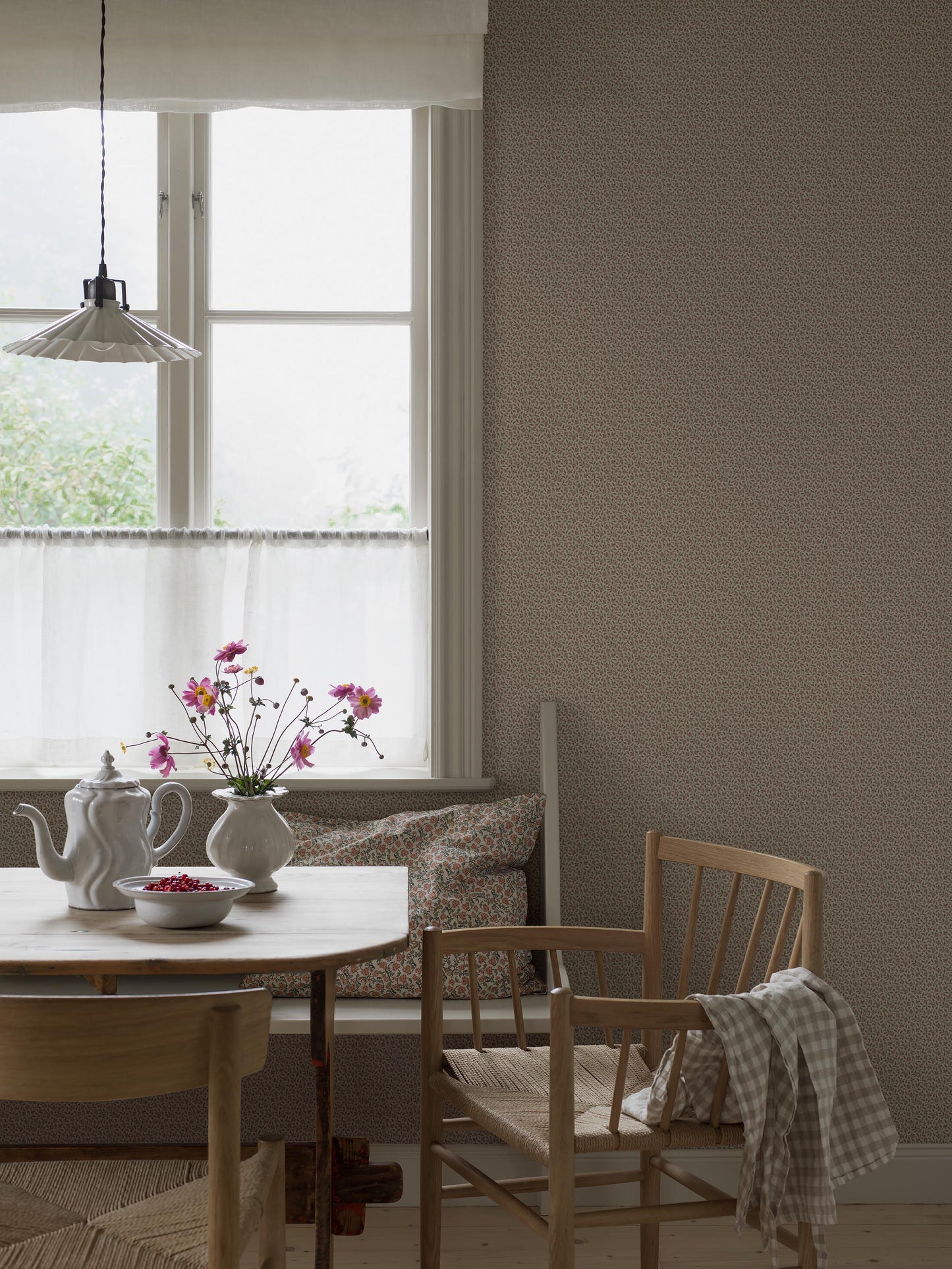 Colored in warm, soft brown tones, our Ida wallpaper features intertwining stems adorned with lush leaves and petite petals that wind naturally across the surface.