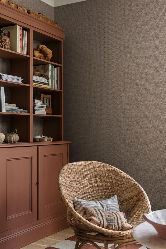 Colored in warm, soft brown tones, our Ida wallpaper features intertwining stems adorned with lush leaves and petite petals that wind naturally across the surface.