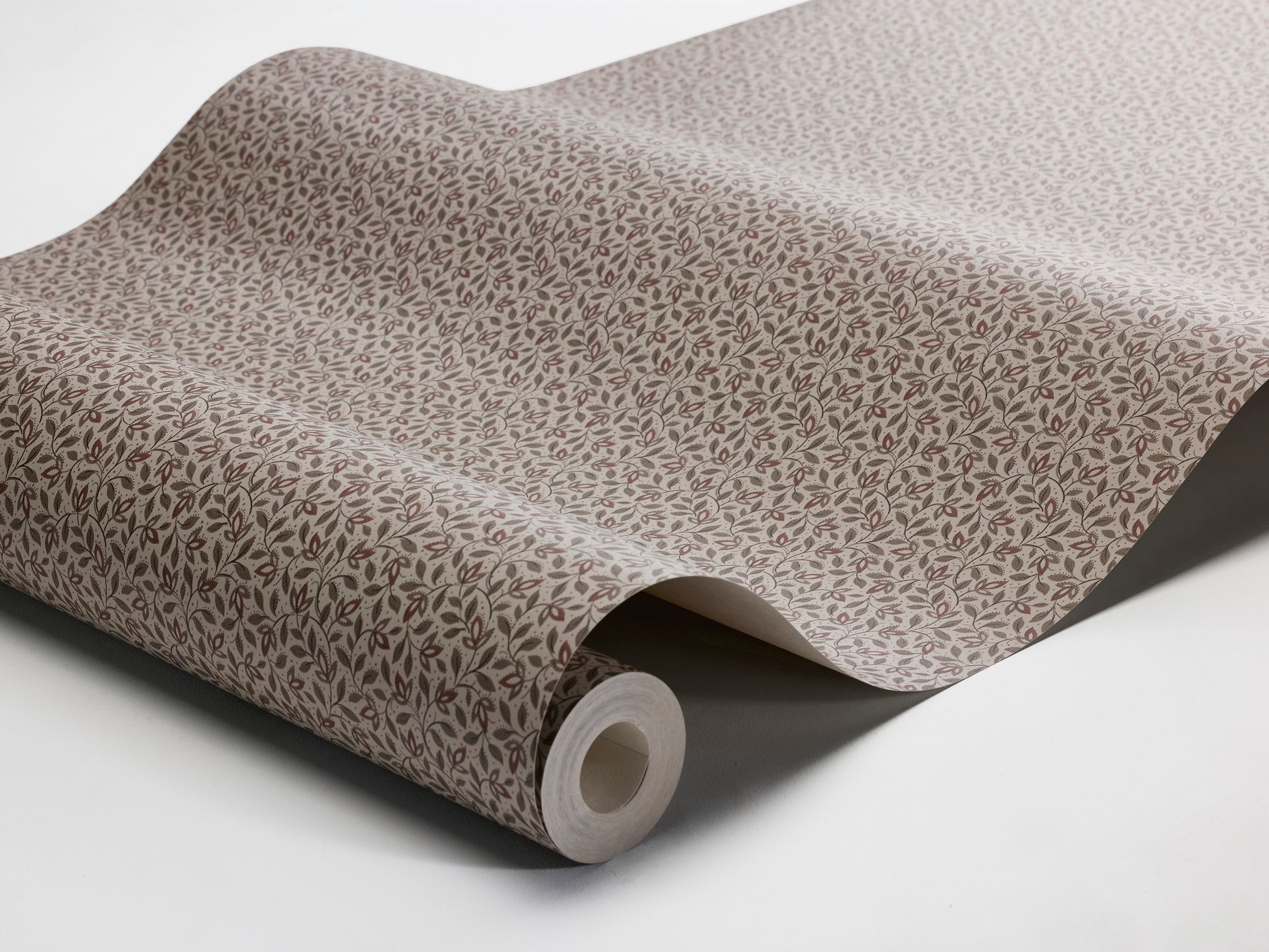 Colored in warm, soft brown tones, our Ida wallpaper features intertwining stems adorned with lush leaves and petite petals that wind naturally across the surface.