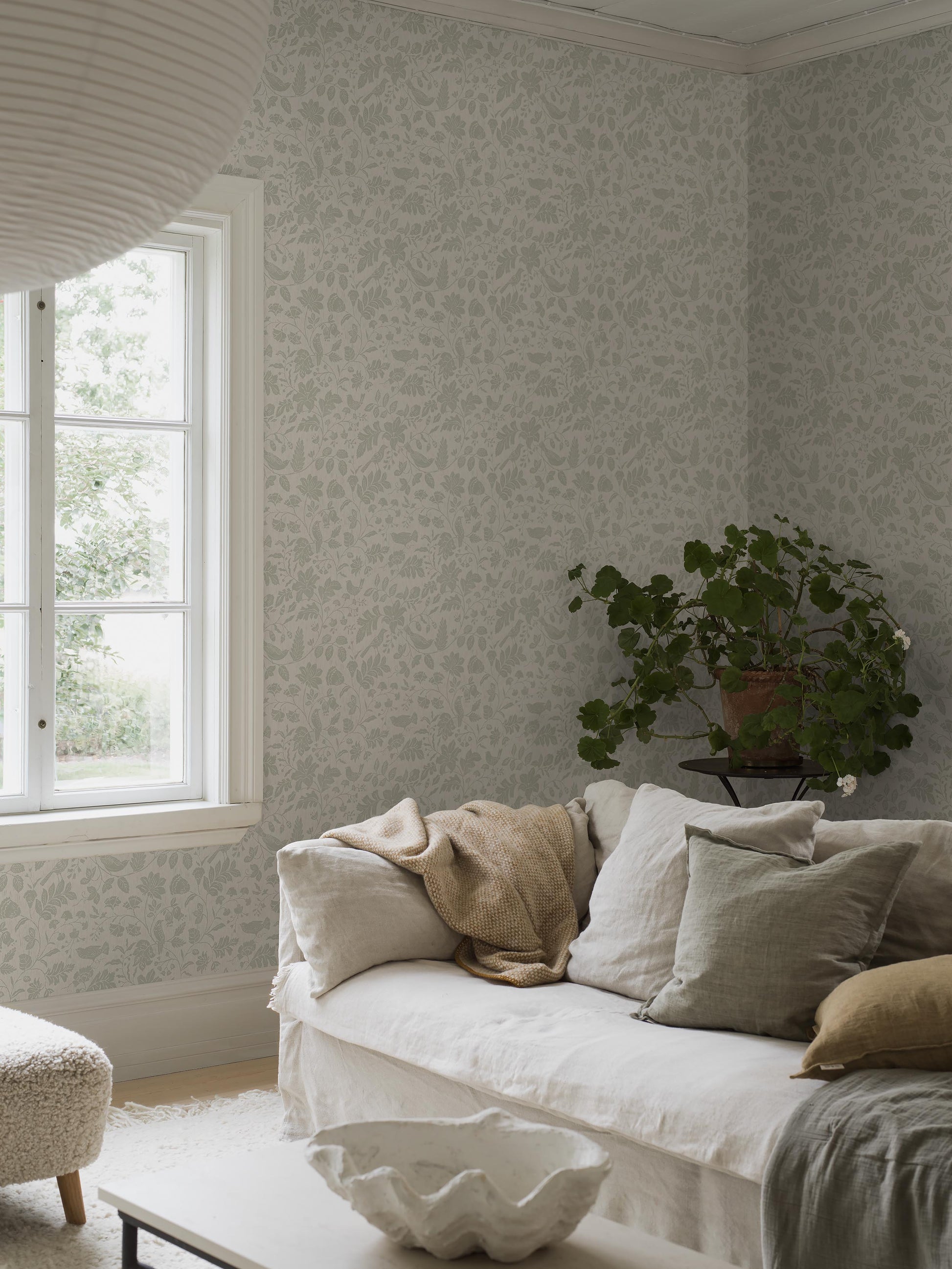 This version of our Isidor wallpaper is colored in light grey-green tones on a cream-white background with discreet streaks of shimmering silver.