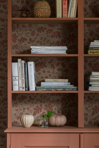 Colored in muted reddish-brown tones on a soft grey-brown base, our Isidor wallpaper reveals a graceful scene of birds and blossoms nestled among leafy branches. 