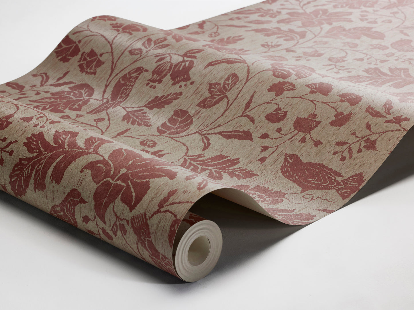 Colored in muted reddish-brown tones on a soft grey-brown base, our Isidor wallpaper reveals a graceful scene of birds and blossoms nestled among leafy branches. 