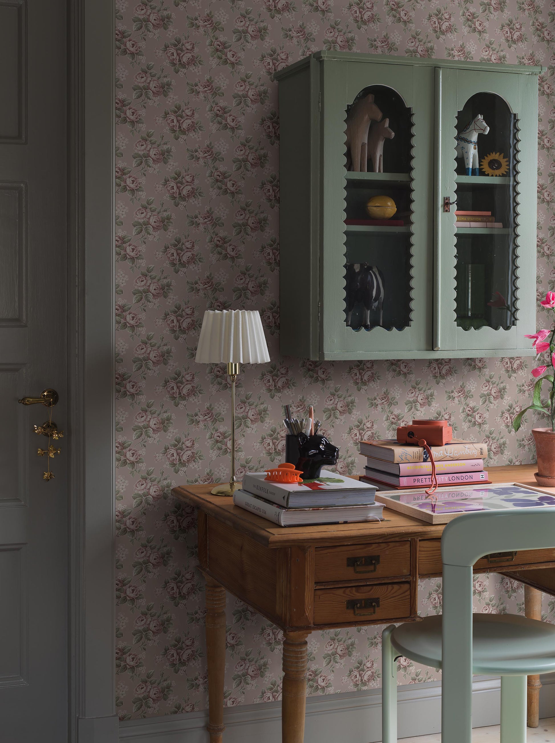 Set on a soft pink background with cool undertones, our Helena wallpaper features flowing rose bouquets in muted shades of pink, green, and cream-white. 
