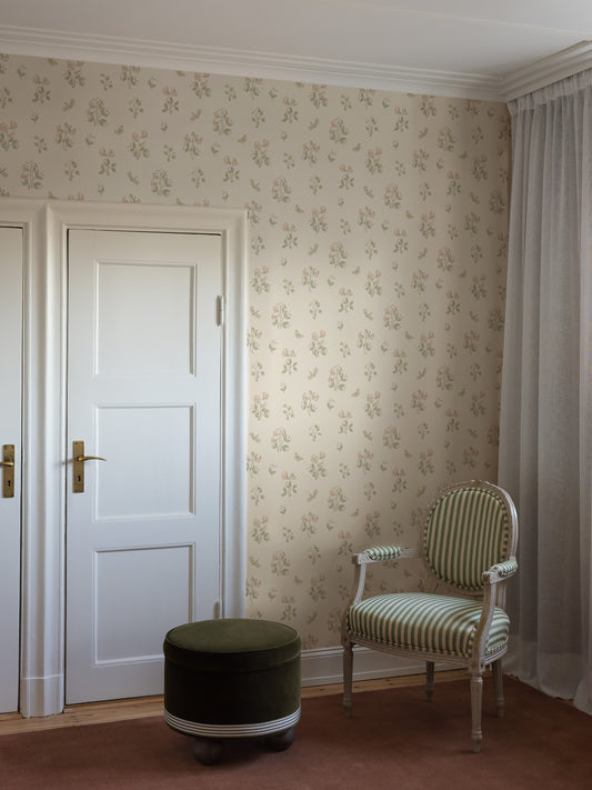The light, Floral wallpaper Luktärt is adorned with sweet peas, sweet violets, dragonflies and butterflies in soft, warm pastel shades of Pink, green and honey yellow on an off-white background. Delightful and Romantic.