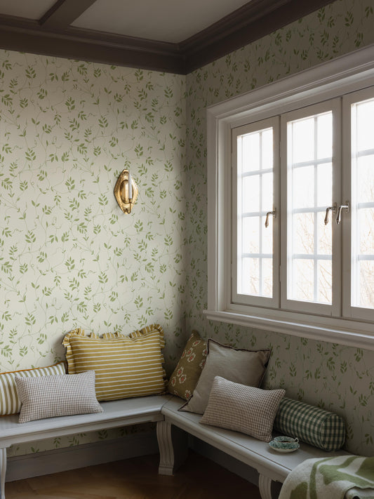 The Klockranka wallpaper is covered in delicate foliage that winds its way up toward the ceiling