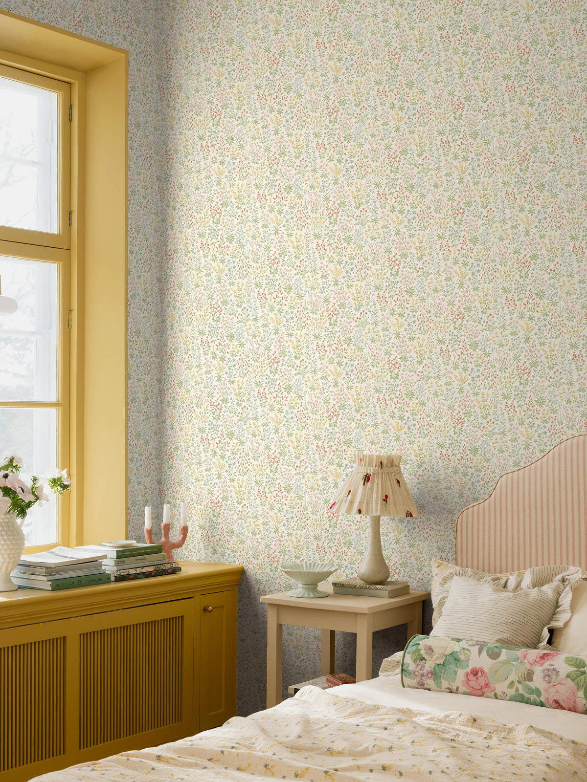 The light, small-flowered wallpaper Vildflora is covered with multicolored, stylized wildflowers.