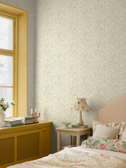 The light, small-flowered wallpaper Vildflora is covered with multicolored, stylized wildflowers.