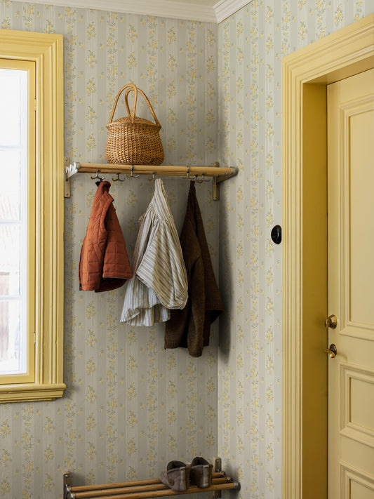 Garlands of black-eyed Susans and sweet little rose bouquets adorn the Striped mural wallpaper Hufvudsta Gård.