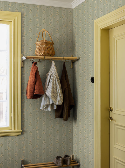 The Striped wallpaper Hufvudsta Gård combines romantic charm with the light, airy expression of the Gustavian style. Here, beige flowers with green leaves wind across light beige stripes – all set against a softly warm green background.
