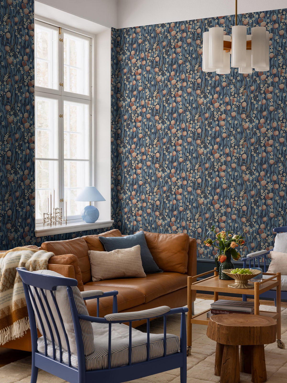 The dark blue Peachtree wallpaper is adorned with apricot-pink peaches and white-pink blossoms in foliage in shades of Blue.