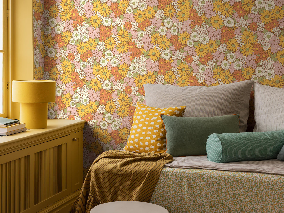 The Floral 1970s wallpaper Flower Power, with its riotous sea of blooms, is taken from our historical archive. A hand-painted pattern featuring, among others, marigold, coneflower, and black-eyed Susan in warm shades of sunny yellow, Orange, Pink, white, and green against a spicy cinnamon-brown background.