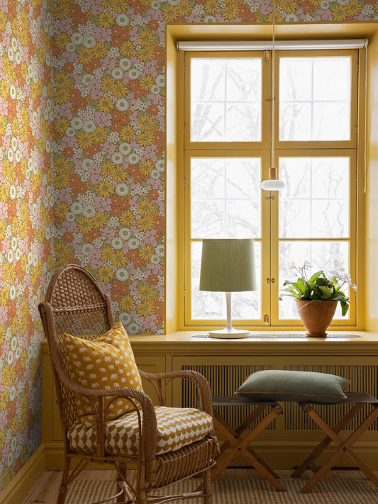 The Floral 1970s wallpaper Flower Power, with its riotous sea of blooms, is taken from our historical archive. A hand-painted pattern featuring, among others, marigold, coneflower, and black-eyed Susan in warm shades of sunny yellow, Orange, Pink, white, and green against a spicy cinnamon-brown background.