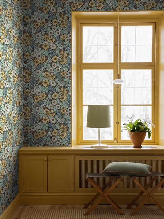 The Floral wallpaper Flower Power is adorned with a dense sea of stylized flowers such as coneflower, marigold and black-eyed Susan. A hand-painted, bold 1970s pattern from our historical archive.