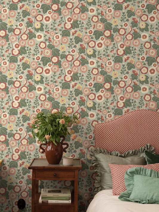 Happy Hollyhocks is a newly drawn floral wallpaper in a retro style – a loving nod to all the fantastic wallpapers from the 1960s and 1970s created in the same naïve, cheerful style.
