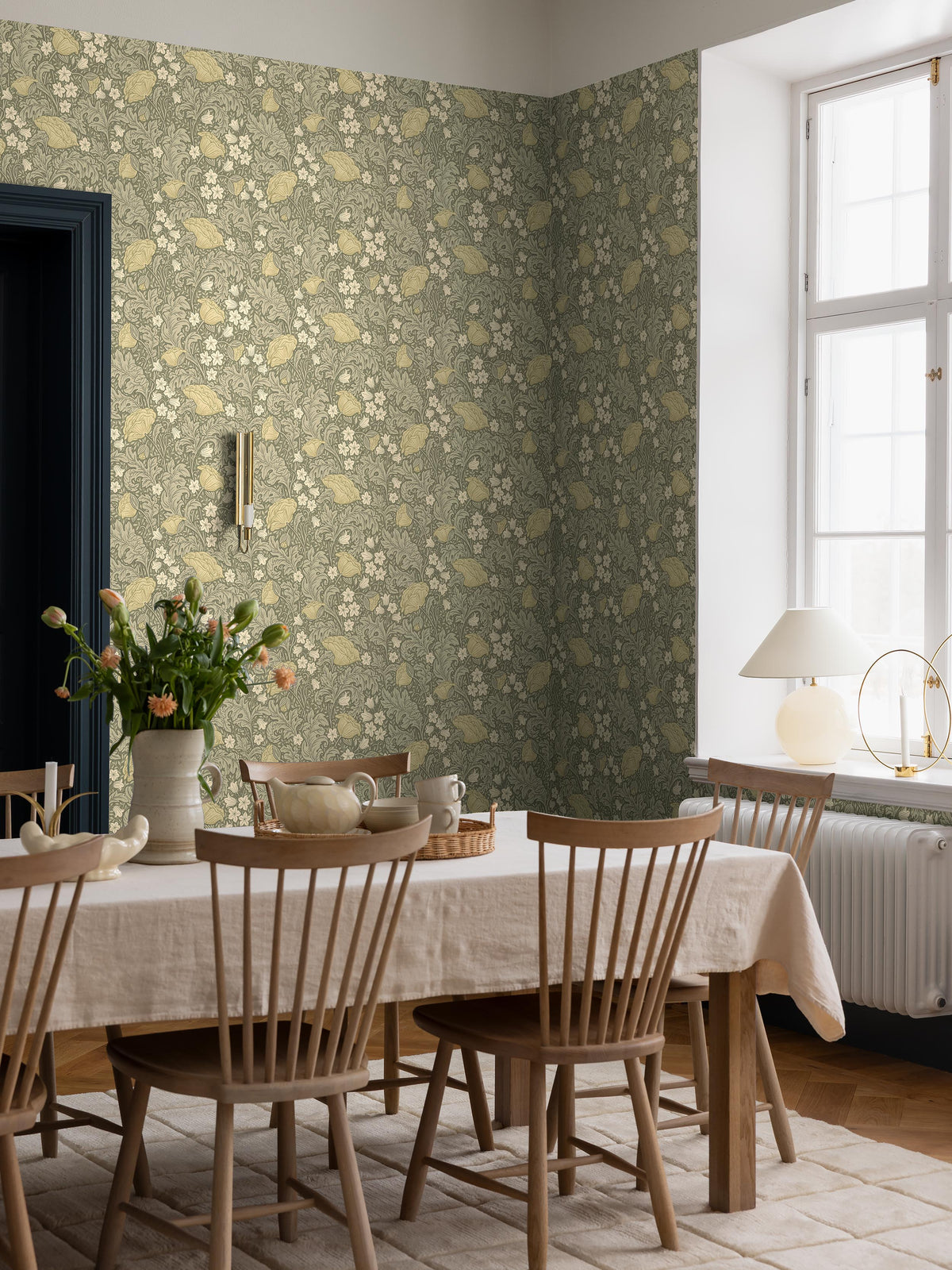 On the green, large-floral wallpaper Blomdansen, the blooms of the peony poppy are joined by beautiful, acanthus-like leaves and delicate bell-shaped flowers on slender stems.