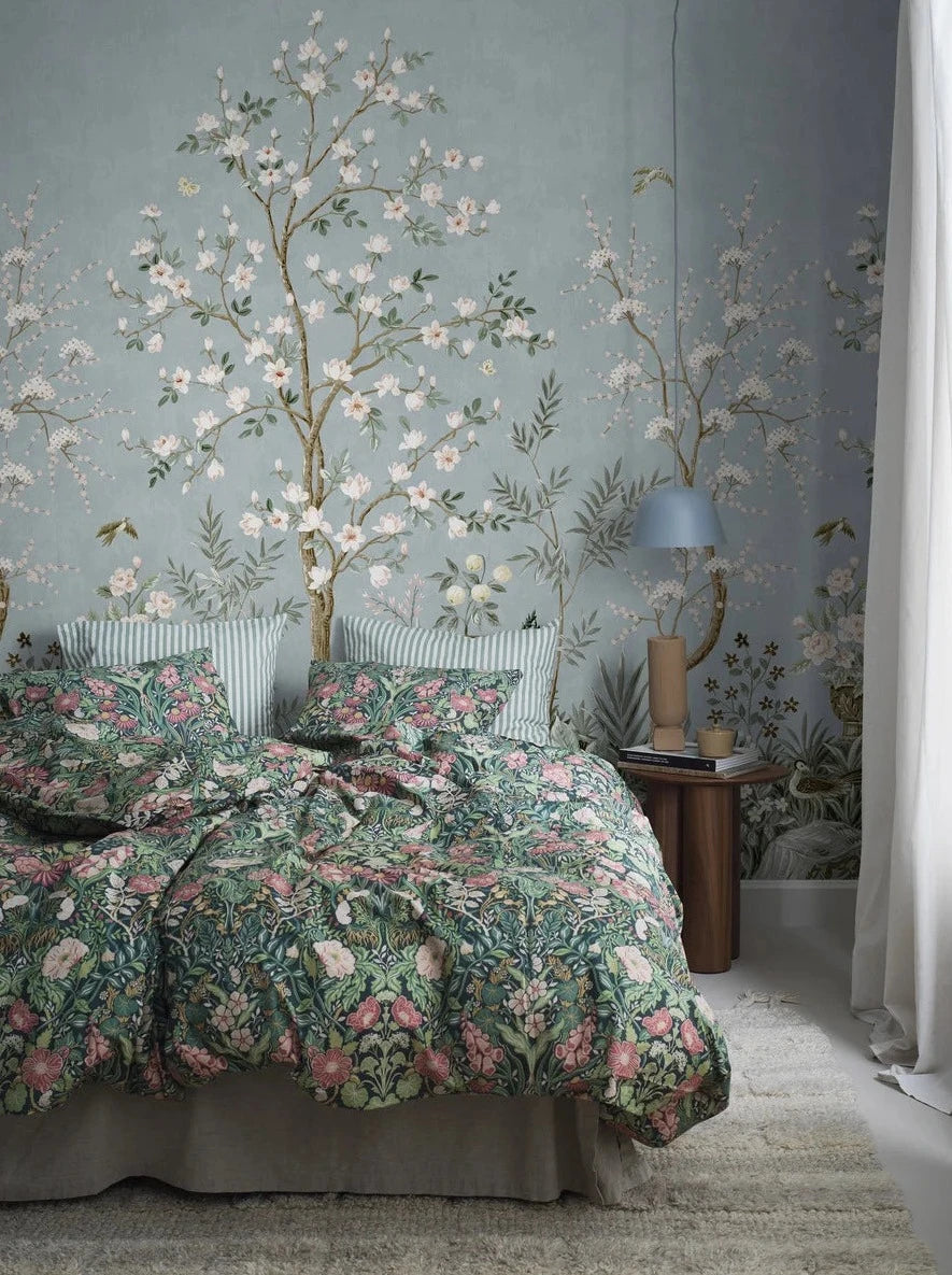 The richly decorated wallpaper Magnolia Garden is adorned with a magical garden in full bloom, with beautiful birds and fluttering butterflies.