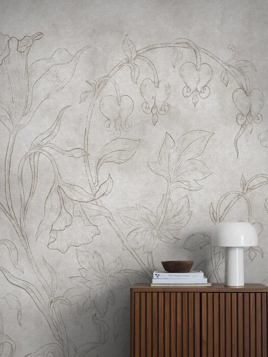 The light gray-beige wallpaper Burning Heart is adorned with delicate bleeding hearts and bellflowers on a discreetly marbled background. 