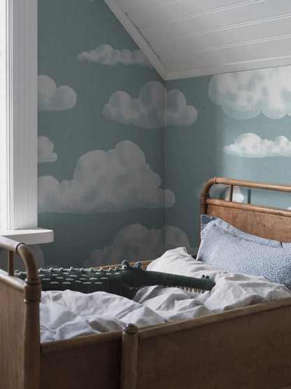 On the children's wallpaper In the Clouds, soft, fluffy clouds drift gently across a light blue-gray sky.